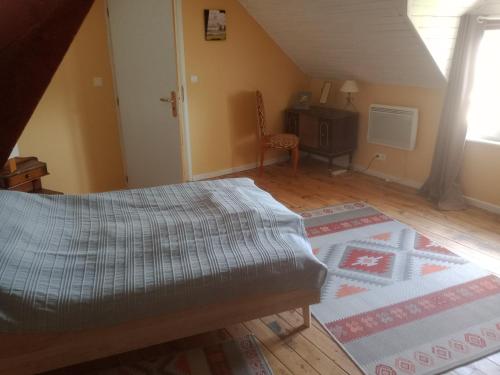 1 dormitorio con 1 cama y 1 alfombra en una habitación en La Petite Cerise, en Eymoutiers