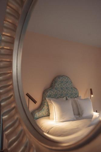 a bedroom with a bed with a chair and a mirror at Flora in Antwerp