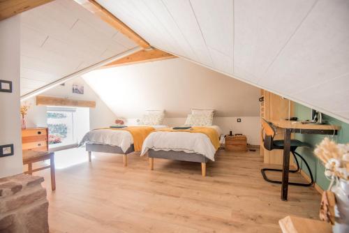 een slaapkamer met 2 bedden op een zolder bij La Loge du Pic Noir in Dabo