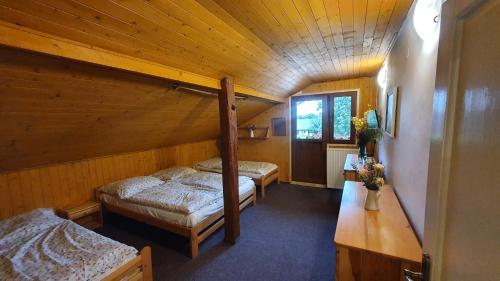 a room with two beds in a wooden cabin at Apartmán U Profesora in Staré Město