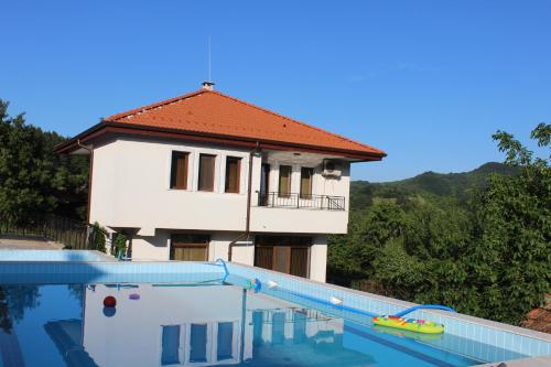 a house with a swimming pool in front of it at Бадевски рай-къща Любов in Badewzi