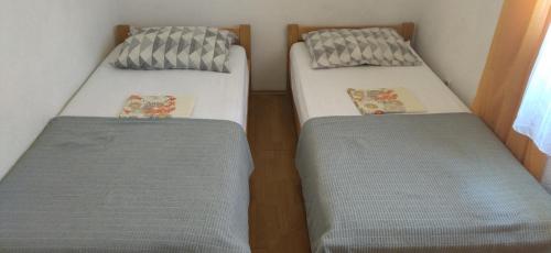 two beds sitting next to each other in a room at Apartments Mara Seget Vranjica in Seget Vranjica