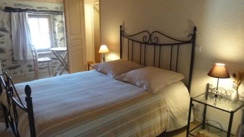 a bedroom with a large bed and two lamps at Le Moulin de Drapras in Chemillé