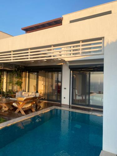 a house with a swimming pool in front of a house at Villa Aleph-Kiralık Müstakil havuzlu lüx villa in Bodrum City