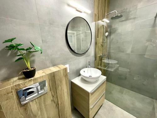 y baño con lavabo y espejo. en Modern Green Apartment en Cracovia