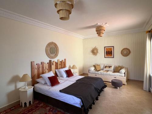 um quarto com uma cama e um sofá em Dar Macha em Ghazoua