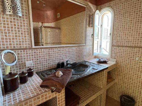 uma casa de banho com um lavatório e um espelho em Dar Macha em Ghazoua