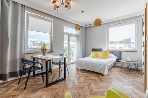 sypialnia z łóżkiem, stołem i krzesłami w obiekcie Copper Apartment w Grudziądzu