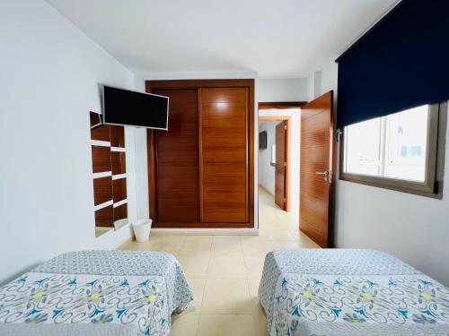 een slaapkamer met 2 bedden en een televisie. bij Apartamento Muelle Deportivo in Las Palmas de Gran Canaria