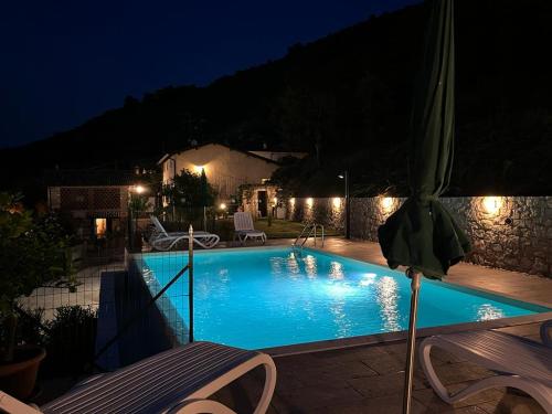 a swimming pool at night with a table and an umbrella at B&B da Cesco in Garda
