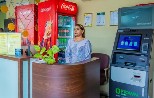 a woman standing in front of a cocacola machine at GS Budget Hotel Ampang in Ampang