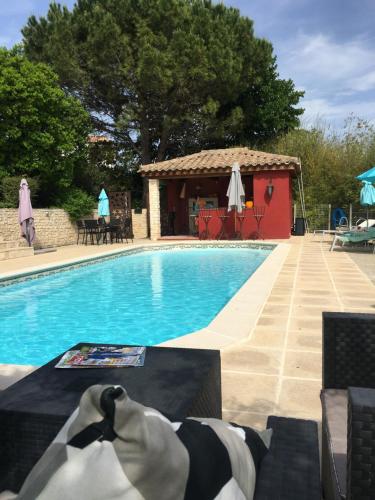 une piscine avec une personne assise sur un banc à côté de celle-ci dans l'établissement Gites Còr Causy MIMOSA, à Causses-et-Veyran