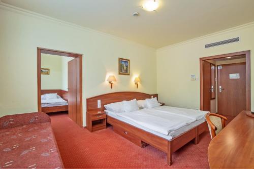 a hotel room with a bed and a mirror at Hungarospa Thermal Hotel in Hajdúszoboszló