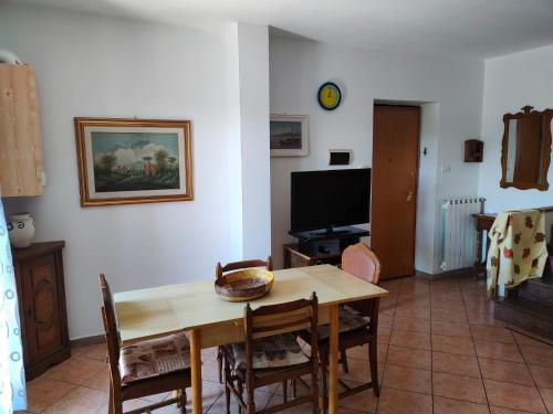 ein Esszimmer mit einem Tisch und einem TV in der Unterkunft Casa Vacanze Palena Adventures in Palena