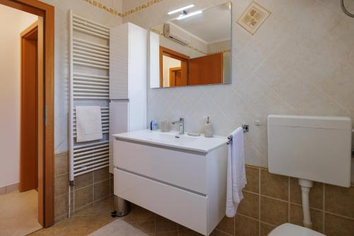 a bathroom with a white sink and a mirror at Apartman La vista e' bella in Kornić