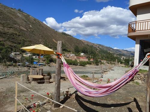 a hammock and an umbrella next to a building at Ecolodge Casa del Montañista in Huaraz