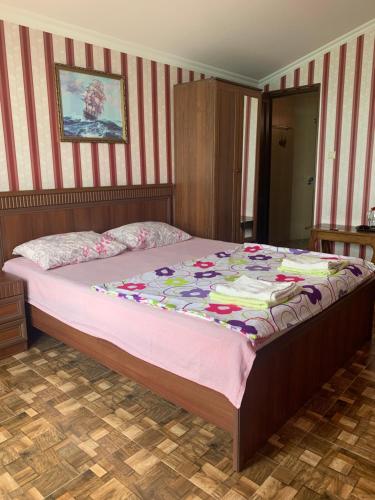 a bedroom with a large bed with pink sheets at Guest House Rusalka in K'obulet'i