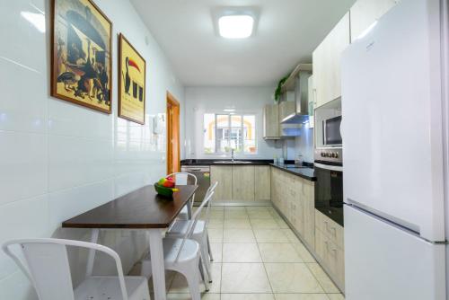 een keuken met een tafel en stoelen en een koelkast bij Casa sol in Vélez-Málaga