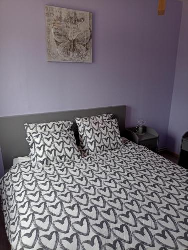 a bed with a black and white comforter and two pillows at Au Bon pl'Han in Han-sur-Lesse