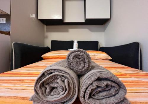 - un lit avec 2 grandes serviettes dans l'établissement Grazioso Appartamento a 10 min da MXP, à Busto Arsizio