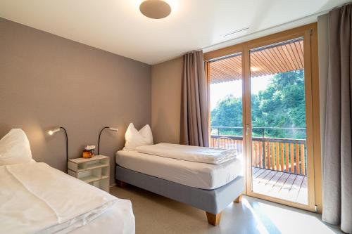 um quarto de hotel com duas camas e uma varanda em Edelweiss Stenna Selva em Flims