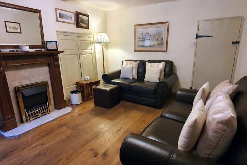a living room with a couch and a fireplace at Anne Cottage, Bakewell, in the Peak District in Bakewell