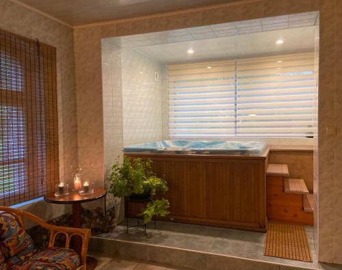 a large bath tub in a room with a window at Karle Hotel in Vitrupe