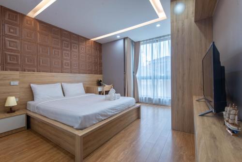 a bedroom with a bed and a television in it at Sunny Home Apartment in Hanoi