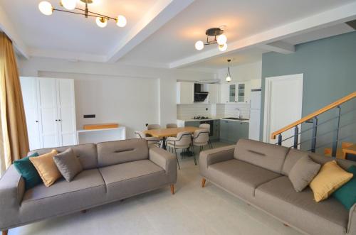 a living room with two couches and a dining room at Juglans Suites in Fethiye