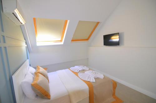 a room with a bed and two windows at Juglans Suites in Fethiye