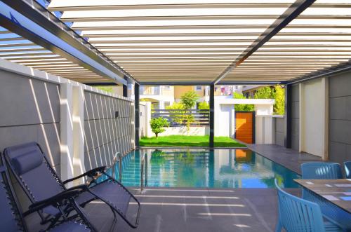 a patio with a swimming pool with a table and chairs at Juglans Suites in Fethiye