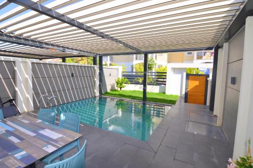 a patio with a swimming pool with a pergola at Juglans Suites in Fethiye