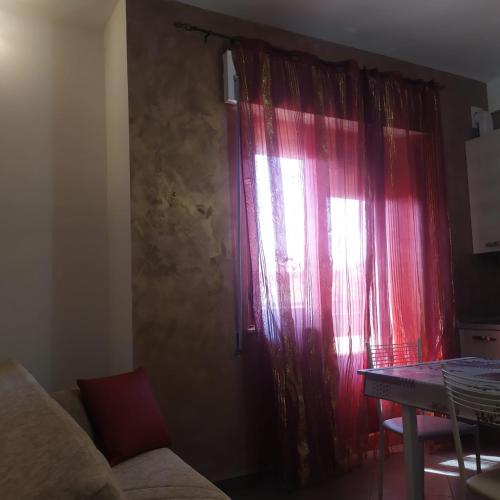 a living room with a red curtain and a table at Terrazza sul Mare in Giulianova