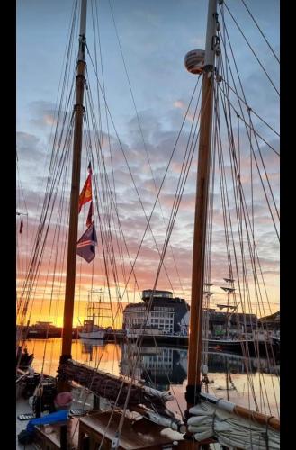 a group of boats docked in a harbor at sunset at LE REFLET DES VOILES FACE AU PORT DE FECAMP in Fécamp