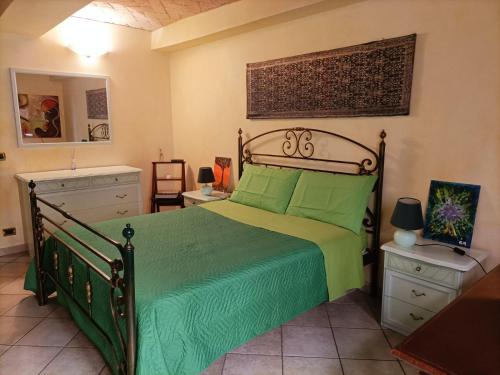 Schlafzimmer mit einem Bett mit grüner Tagesdecke in der Unterkunft Il Gioiellino di Modena - Elegant Apartment[☆☆☆☆☆] in Modena