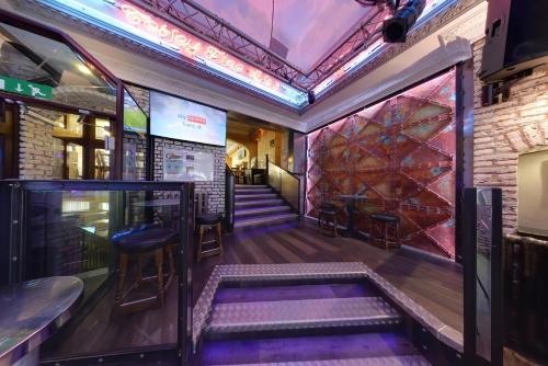 a room with stairs and a bar with purple lighting at The George Hotel in Whitby