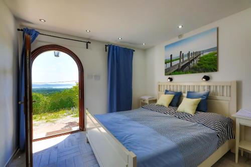 um quarto com uma cama e uma grande janela em Fishing & Golf Kisleshegy Balatonudvari Vendégház em Balatonudvari