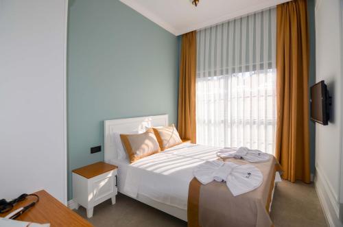 a bedroom with a bed with a bow on it at Juglans Suites in Fethiye
