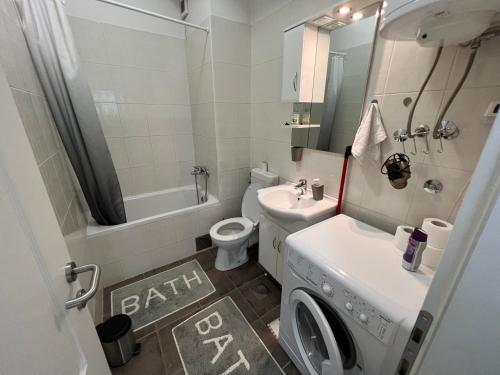 ein Badezimmer mit einem Waschbecken und einer Waschmaschine in der Unterkunft Jimmy's Apartment in Sarajevo