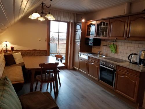 eine Küche und ein Wohnzimmer mit einem Tisch und einem Sofa in der Unterkunft Trippolthof in Prebl