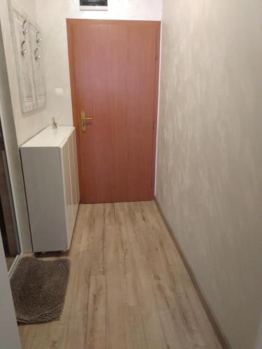 a hallway with a brown door and a wooden floor at Apartments Dani in Pomorie