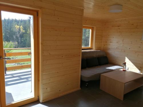 Habitación pequeña con sofá y ventana en Karavanke mountain hut, en Jesenice
