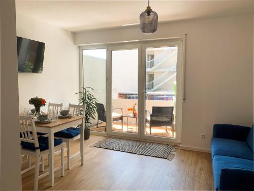 a living room with a dining room table with a view at Casa d‘Oro in Friedrichshafen