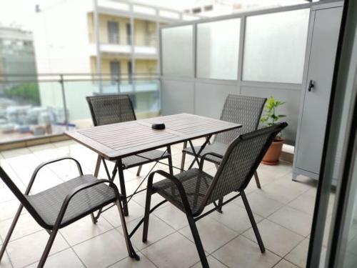 a table and four chairs on a balcony at Greg's Home Volos in Volos