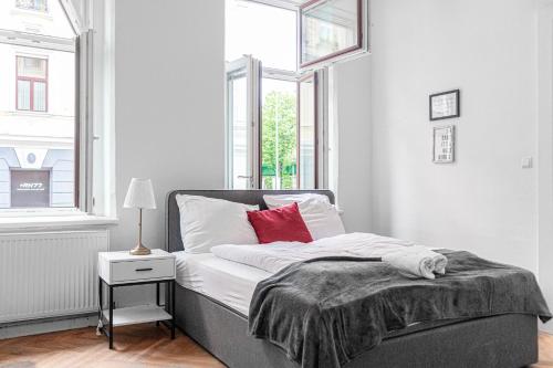 sypialnia z łóżkiem z czerwoną poduszką w obiekcie Classy 2BR Apt. w/ Exclusive Location near AKH w Wiedniu
