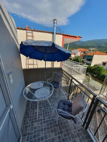 a patio with a table and chairs and an umbrella at Villa Fer Forze you have the feeling of your own holiday home in Asprovalta