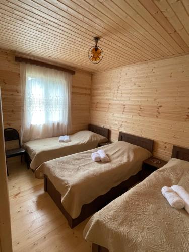 Zimmer mit 3 Betten in einer Holzhütte in der Unterkunft Warm House in Kazbegi