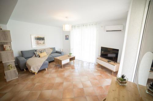 a living room with a couch and a tv at AZALEA - Modern studio with sea view in Galatas