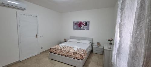 a bedroom with a bed in a white room at Appartamento Centro Niscemi in Niscemi