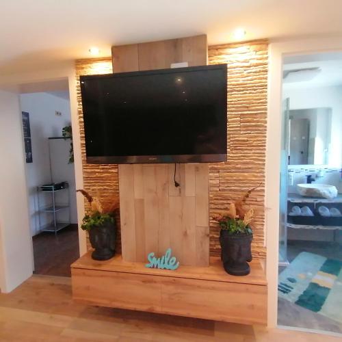 a flat screen tv on a wooden stand in a living room at Ferienwohnung Berg(Aus)zeit Ennstal in Öblarn